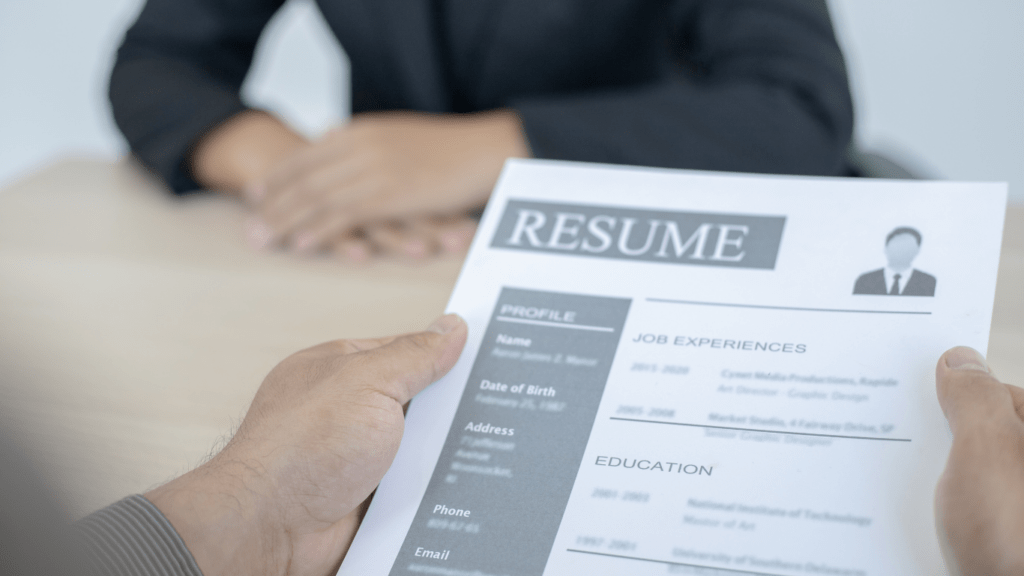 a person is holding a resume in front of another person