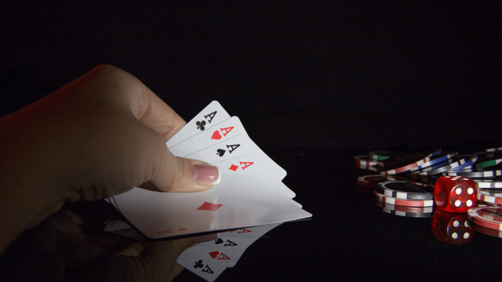 a hand holding cards and chips