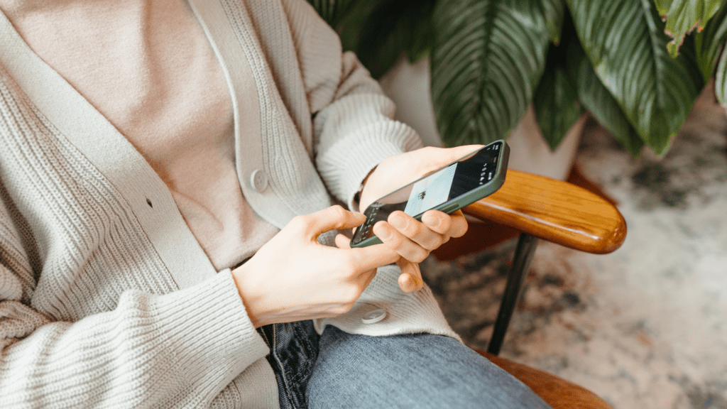 a person is using their phone while sitting in a chair