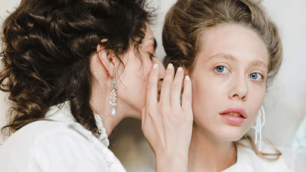 two women are talking and one of them is wearing earrings