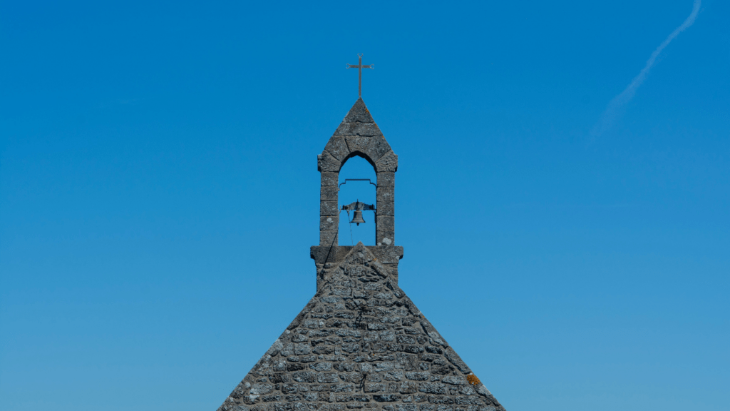 a bell tower with a cross on top of it